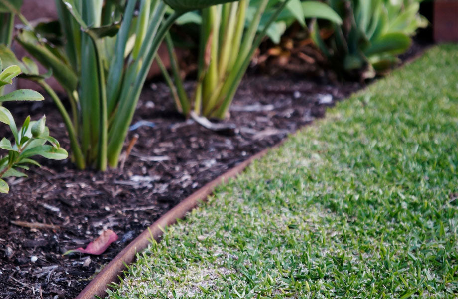 metal garden edging in a rustic garden with lawn and garden beds