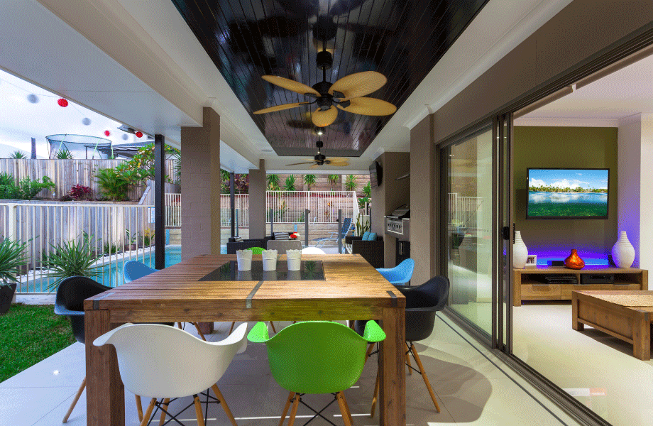 outdoor entertaining space ideas in this case a patio area with a wooden table and green and white chairs next to a green space and pool