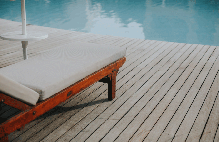 image of a pool with a deck and orange and white deck chair for pool area ideas