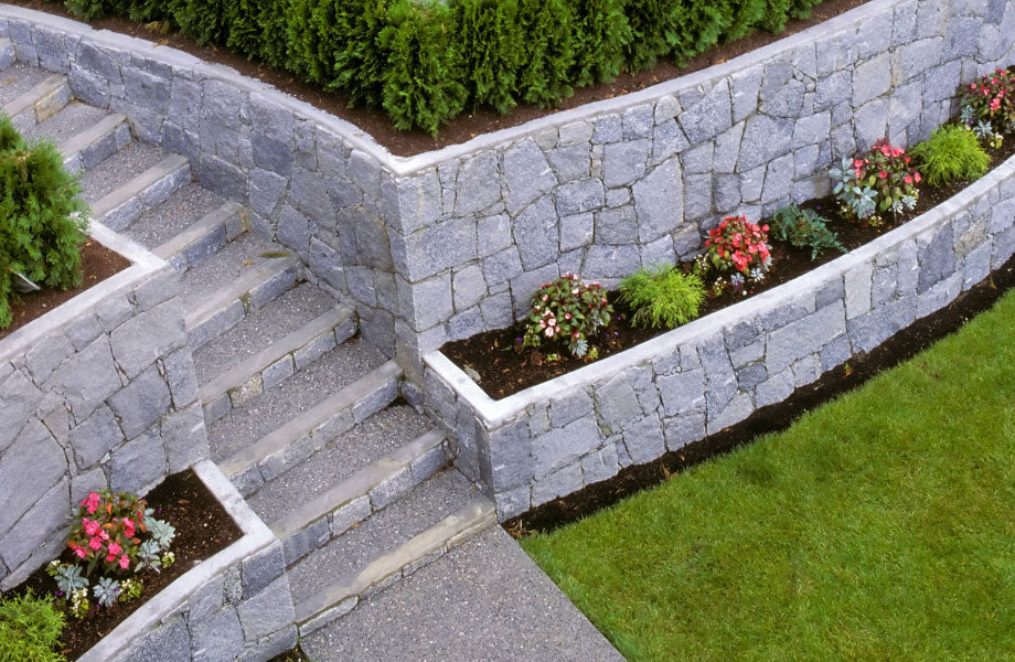 image of retaining walls and a paved path with stairs dotted with garden beds for masonry maintenance