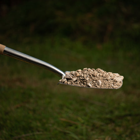 shovel with a pile of rocks against natural background