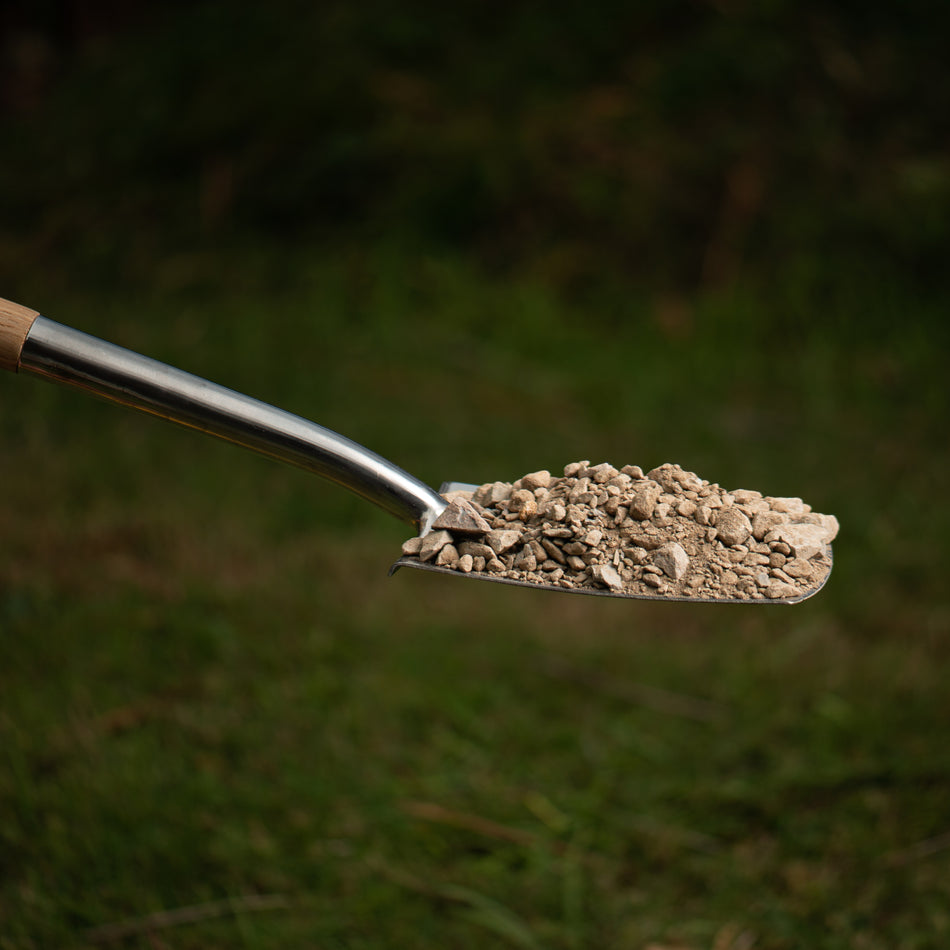 shovel with a pile of rocks against natural background