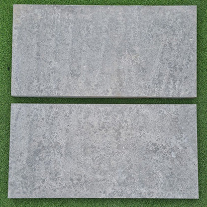 Two gray rectangular steppers on a green background