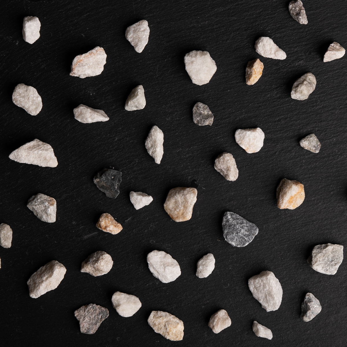 Small stones scattered on a black surface