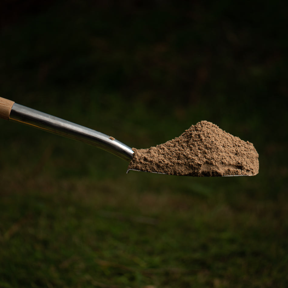 shovel full of sand on outdoor background