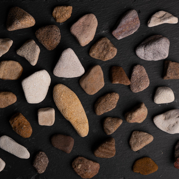 Assorted small rocks on a dark surface