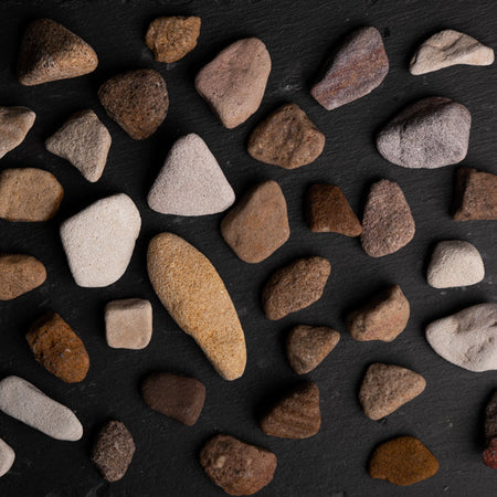 Assorted small rocks on a dark surface