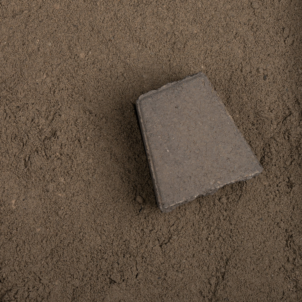 Gray concrete block on a sandy surface