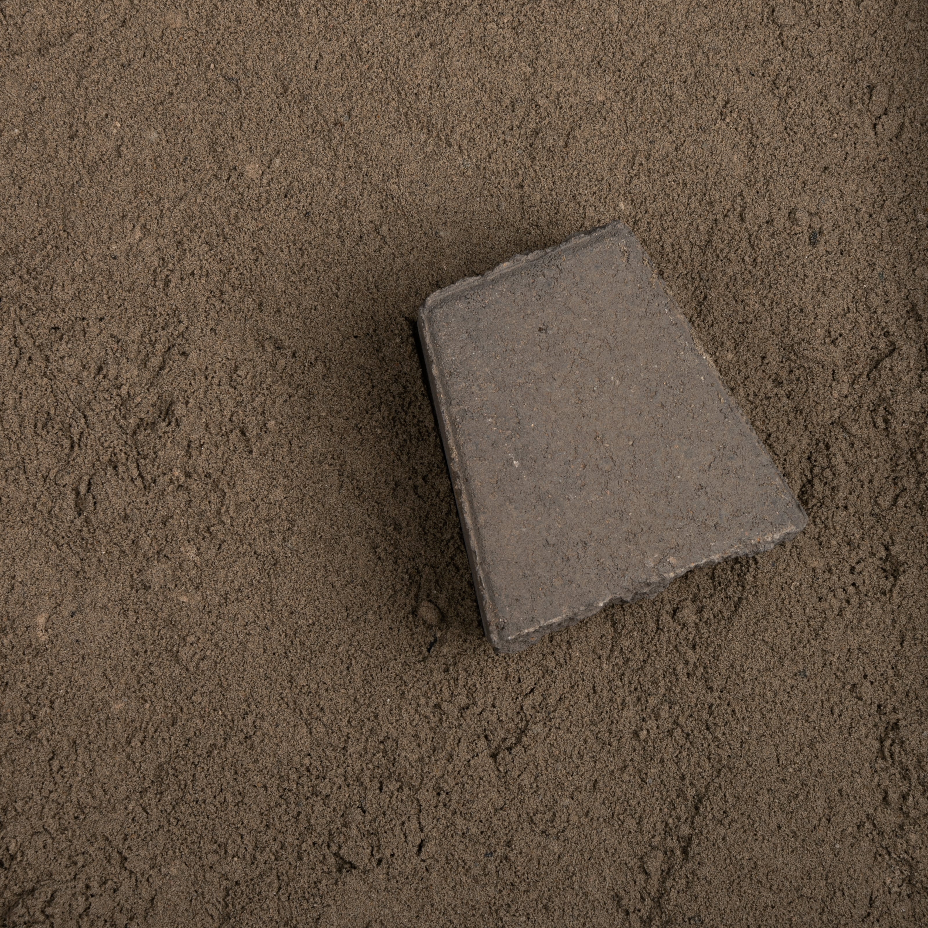 Gray concrete block on a sandy surface