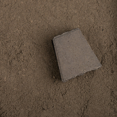 Gray concrete block on a sandy surface