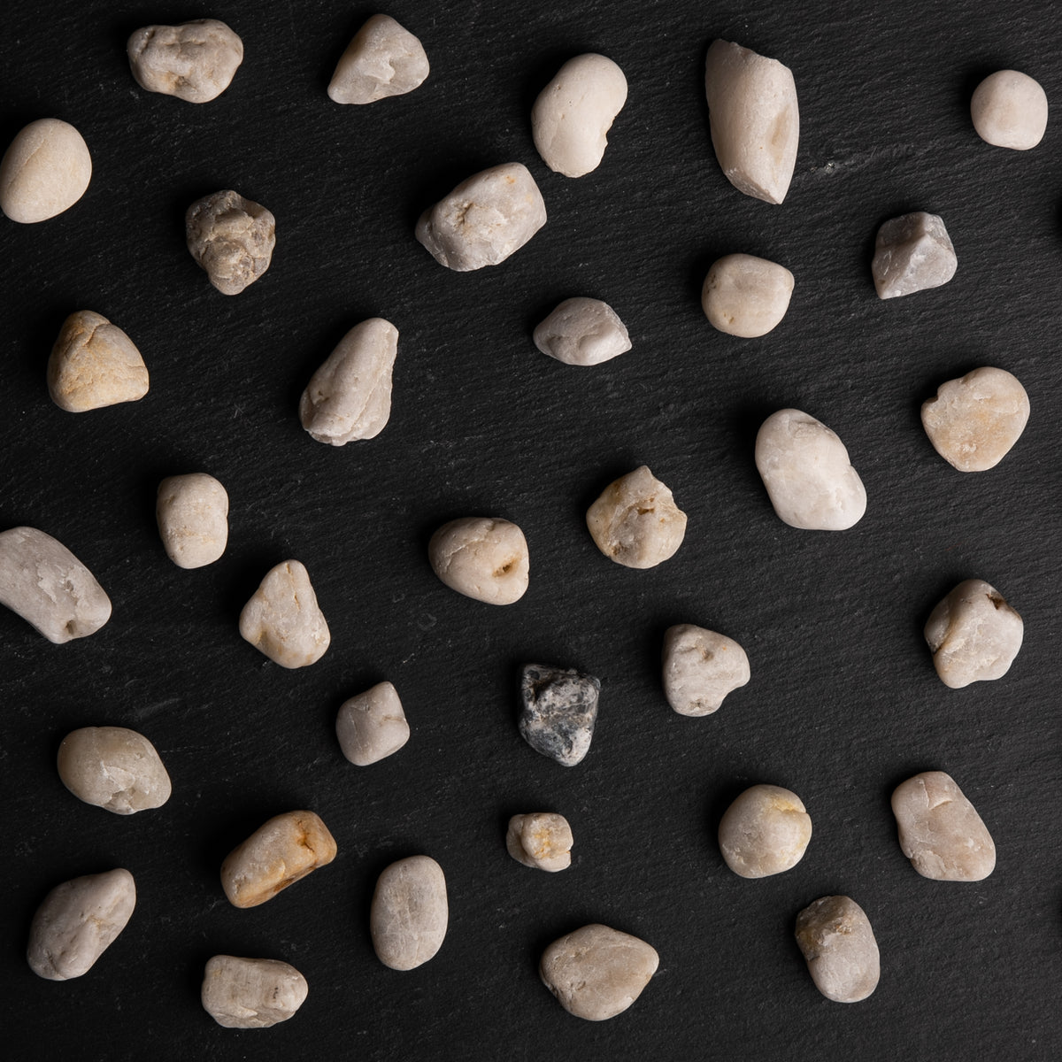 Small rocks scattered on a dark slate surface