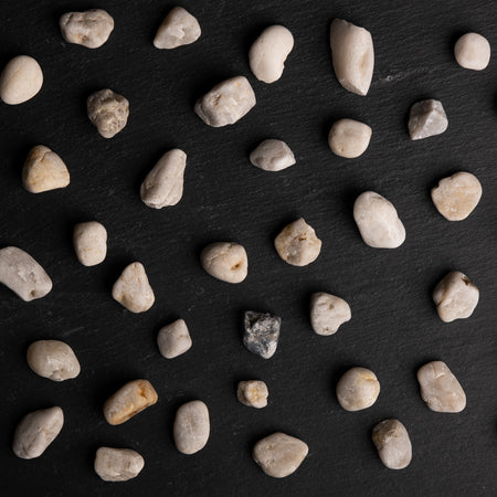 Small rocks scattered on a dark slate surface