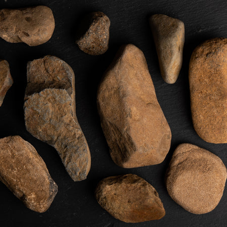 Assorted brown rocks on a dark surface