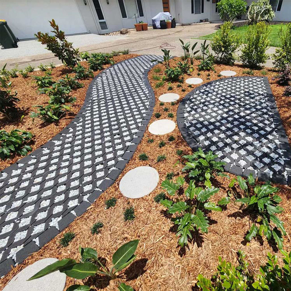 Decorative stepping stones with a geometric pattern in a garden setting.