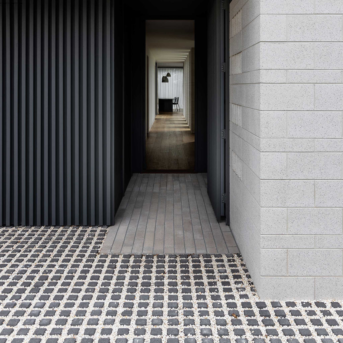 Modern architectural interior with a black wall, tiled floor, and light gray walls.