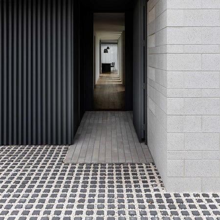 Modern architectural interior with a black wall, tiled floor, and light gray walls.