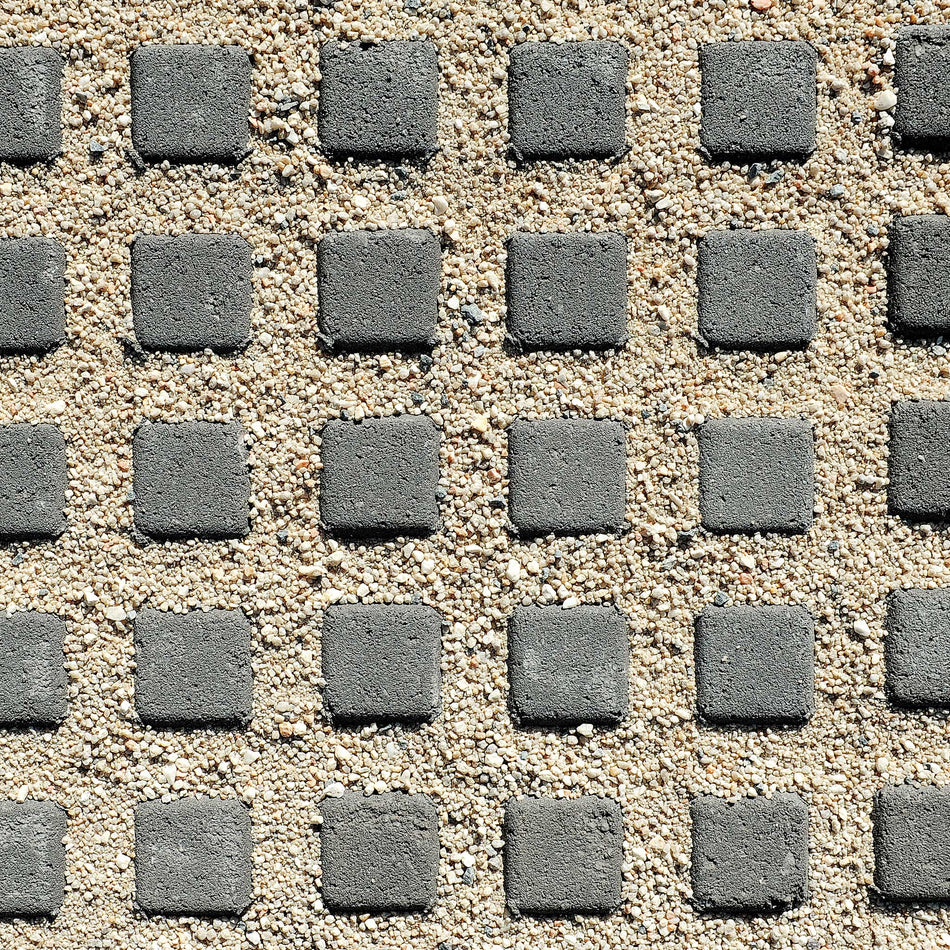 Pattern of gray square stones on a sandy surface