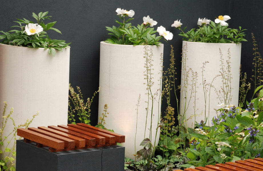 white pots with flowers in garden