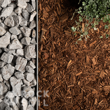 image of pebbles next to cypress blend mulch with garden edging between