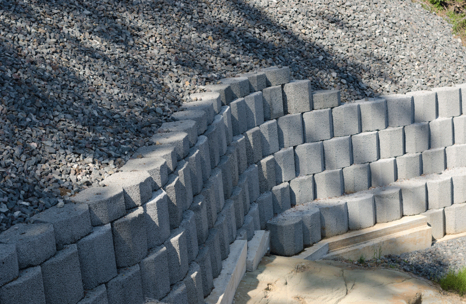 image of serpentine concrete block retaining wall with gravel backing for how to build a curved retaining wall