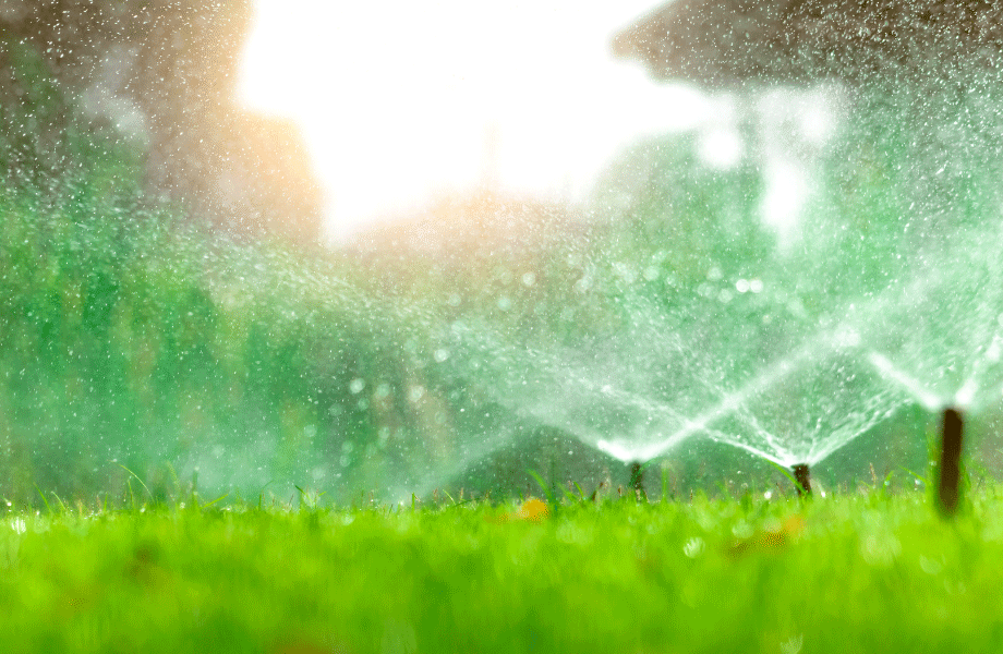 image of sprinkler lawn irrigation system spraying water on the grass in the sunlight