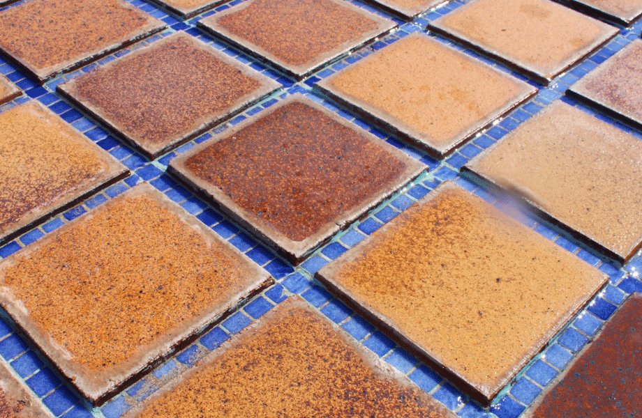close up image of orange pool tiles with blue smaller tiles between