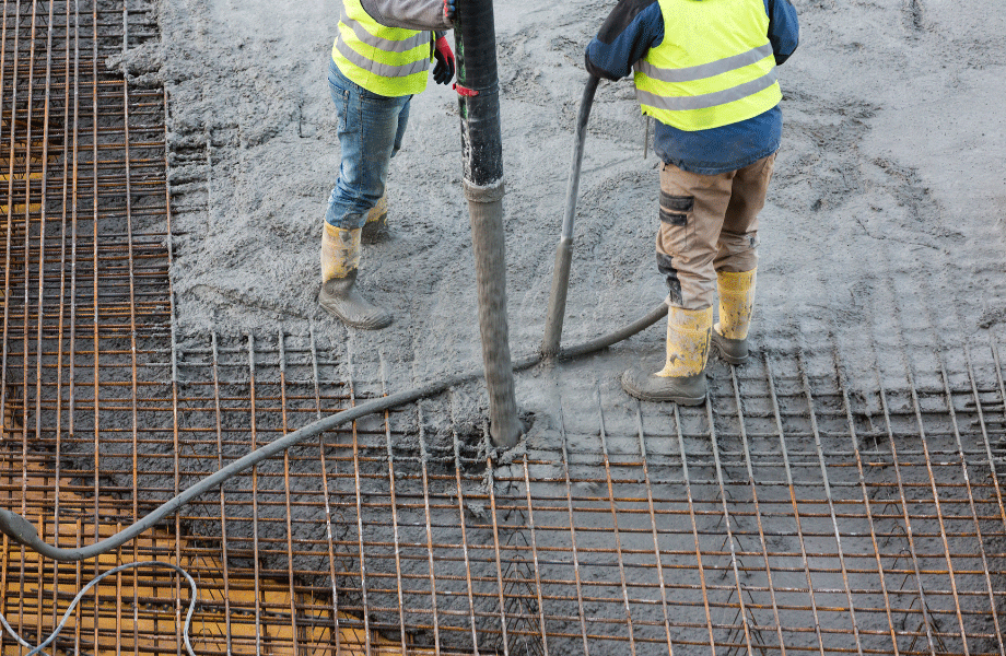 two workers in high vis pouring concrete into a laid grid for difference between cement and concrete